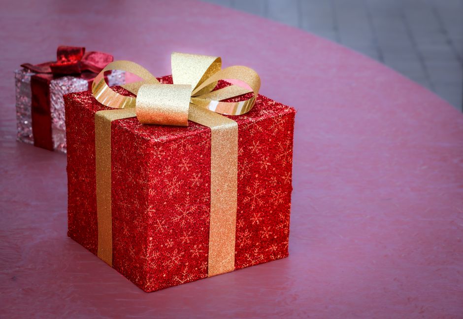 Cadeau rouge festif avec un ruban doré sur une table, idéal pour emballer des chocolats maison.