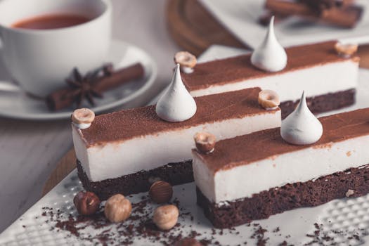 Desserts au chocolat avec meringue et praliné, décorés de noisettes et présentés avec une tasse de café.