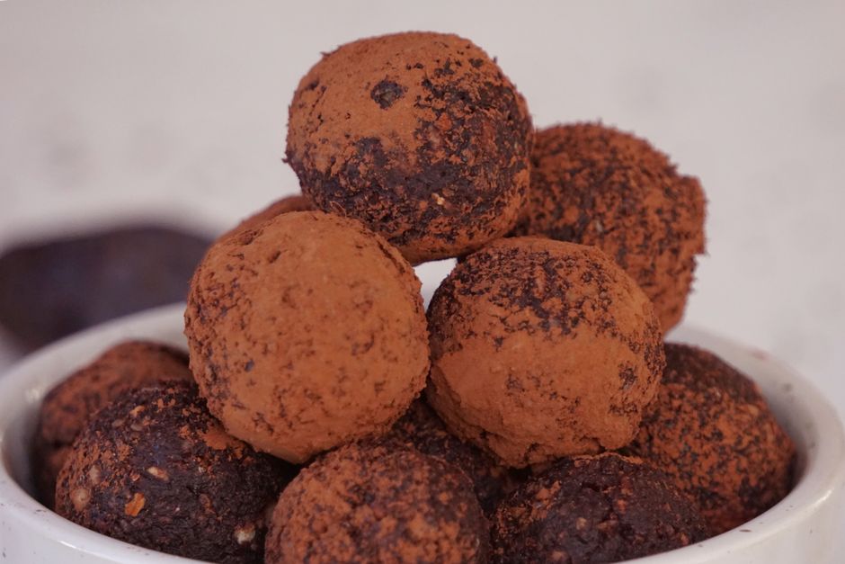 Bol rempli de truffes au chocolat enrobées de cacao, prêtes à être offertes.