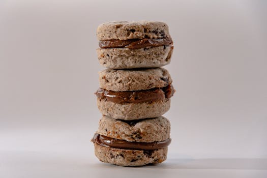 Trois sablés au chocolat empilés, garnis de crème pralinée, sur fond neutre.