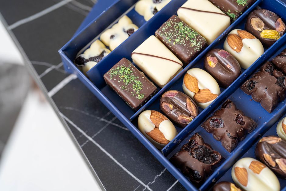 Assortiment de confiseries élégantes : orangettes et mendiants en chocolat avec fruits secs et éclats de pistache.