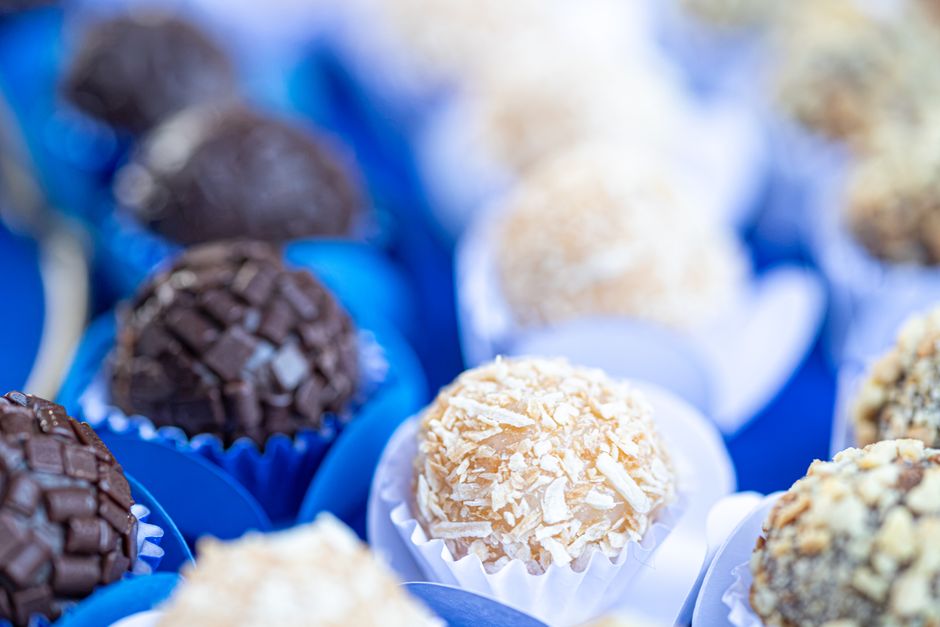 Assortiment de truffes au chocolat présentées dans des caissettes, avec différentes garnitures et textures.