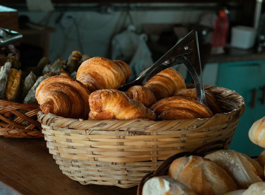 Panier en osier rempli de croissants dorés et croustillants, idéal pour une box gourmande faite maison.